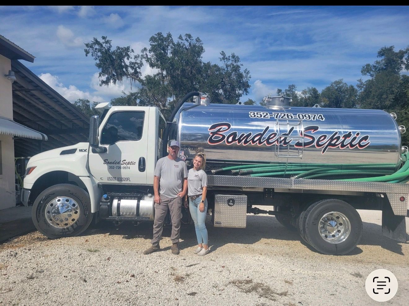 Bonded Septic Tank pump truck with company owners standing beside it